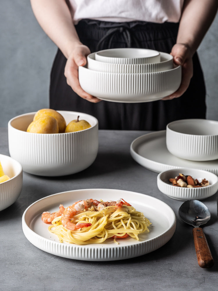 Hualian Yijia Plate Dish Set featuring various dishes and bowls in a stylish setting with pasta and fruits.